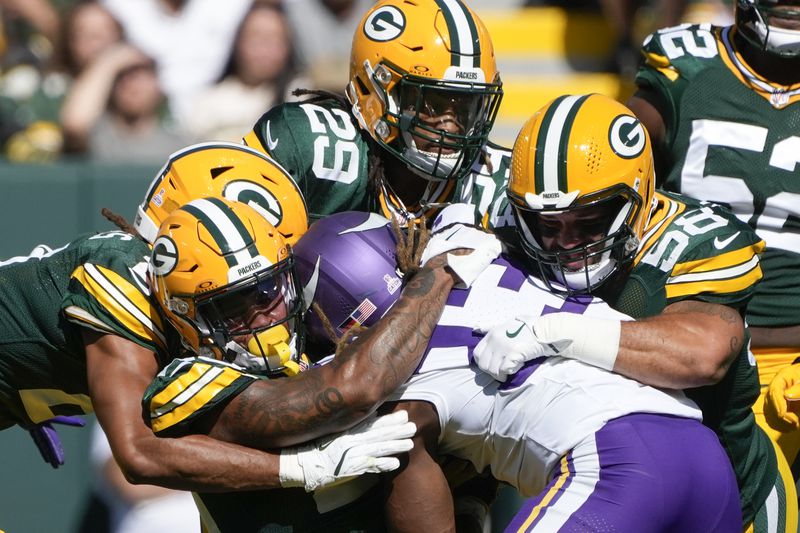 Green Bay Packers defenders tackle Minnesota Vikings running back Aaron Jones, center, during the first half of an NFL football game Sunday, Sept. 29, 2024, in Green Bay, Wis. (AP Photo/Morry Gash)