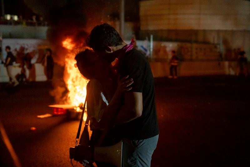 Two people kiss during a protest calling for a deal for the immediate release of hostages held in the Gaza Strip by Hamas, in Tel Aviv, Israel, Sunday, Sept. 1, 2024. (AP Photo/Ohad Zwigenberg)