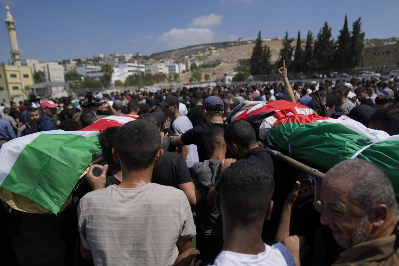 Mourners take part in a funeral of four Palestinians who died during an Israeli military operation in the West Bank refugee camp of Al-Faraa, near Tubas, Thursday, Aug. 29, 2024. (AP Photo/Nasser Nasser)