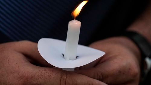 Mark Gorman holds a candle during a candlelight vigil for the slain students and teachers at Apalachee High School, Wednesday, Sept. 4, 2024, in Winder, Ga. (AP Photo/Mike Stewart)