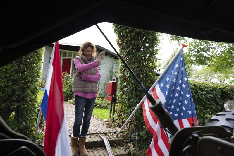 A resident waves as a jeep passes during a ceremony marking the 80th anniversary of the liberation of the south of the Netherlands in Mesch, Thursday, Sept. 12, 2024. (AP Photo/Peter Dejong, Pool)