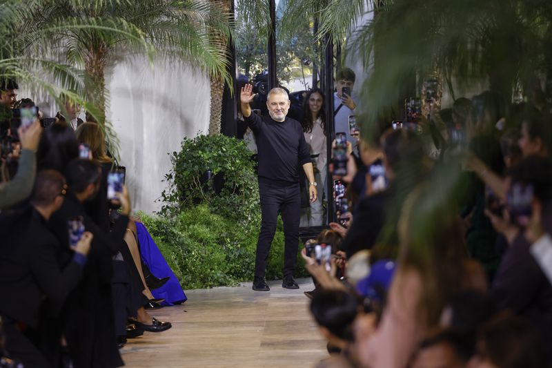 Designer Elie Saab acknowledges applause after his Spring/Summer 2025 collection presented Saturday, Sept. 28, 2024, in Paris. (Photo by Vianney Le Caer/Invision/AP)