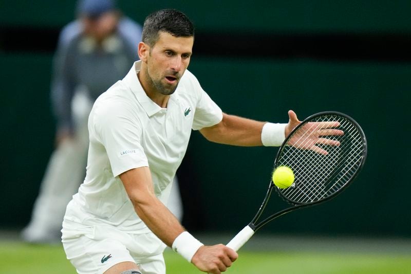 Novak Djokovic of Serbia plays a backhand return to Holger Rune of Denmark during their fourth round match at the Wimbledon tennis championships in London, Monday, July 8, 2024. (AP Photo/Mosa'ab Elshamy)