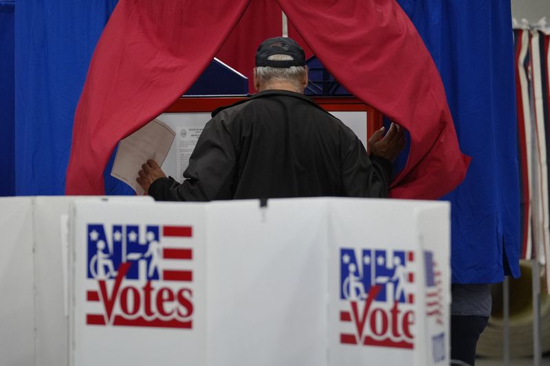 A voter enters a booth fill out a ballot in a primary election to pick candidates for governor, the U.S. House, and the state Legislature, Tuesday, Sept. 10, 2024, in Nashua, N.H. (AP Photo/Steven Senne)