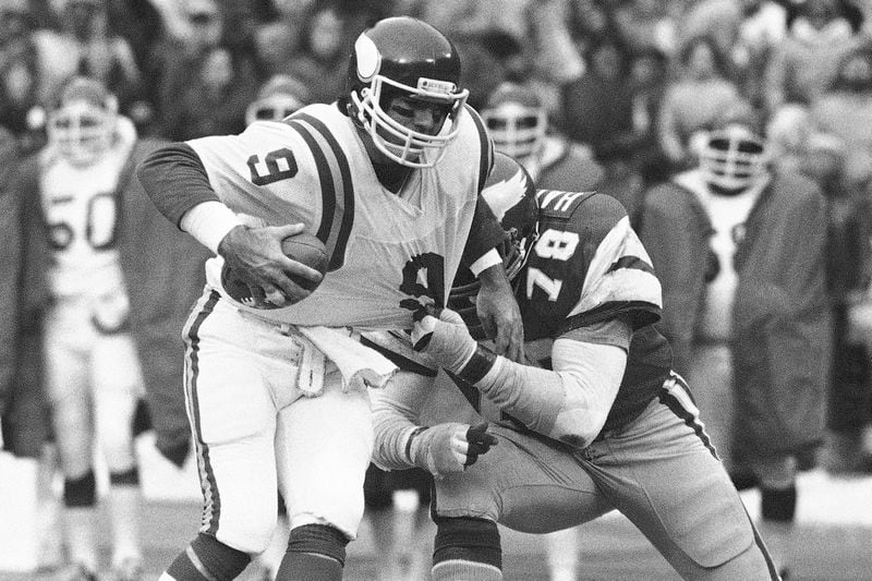 FILE - Minnesota Vikings quarterback Tommy Kramer tries to get away from the grasp of Philadelphia Eagles Carl Hairston during an NFC semi-final playoff football game in Philadelphia on Saturday, Jan. 3, 1981. (AP Photo/Clem Murray, File)