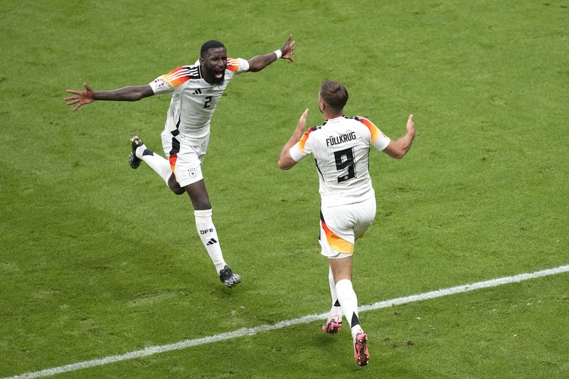 Germany's Niclas Fuellkrug celebrates with Germany's Antonio Ruediger after scoring his side's second goal during a Group A match between Switzerland and Germany at the Euro 2024 soccer tournament in Frankfurt, Germany, Sunday, June 23, 2024. (AP Photo/Michael Probst)