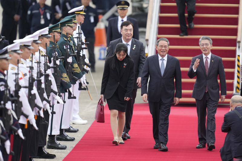 Chinese Premier Li Qiang, second right, is welcomed by Kim Hong-kyun, right, South Korean 1st vice minister, as the premier arrives for a trilateral meeting, at the Seoul airport in Seongnam, South Korea, Sunday, May 26, 2024. Leaders of South Korea, China and Japan will meet next week in Seoul for their first trilateral talks since 2019. (AP Photo/Lee Jin-man)