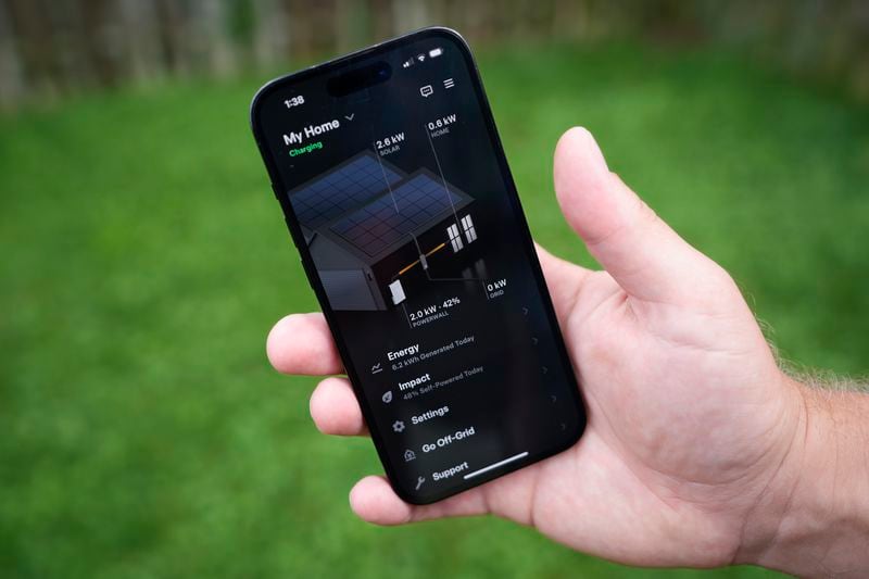 Jason Benedict shows an app on his phone with solar energy readings of his home in Berkley, Mich., Wednesday, July 24, 2024. (AP Photo/Paul Sancya)