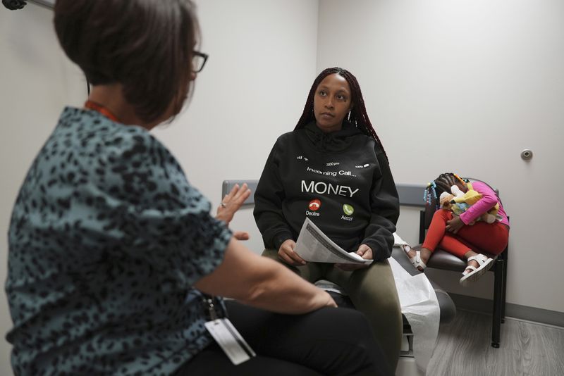 Areana Coles listens to Healthy Start care coordinator Krystal Keener during a prenatal appointment at the Oklahoma State University obstetrics and gynecology clinic in Tulsa, Okla., on Tuesday, July 16, 2024. (AP Photo/Mary Conlon)