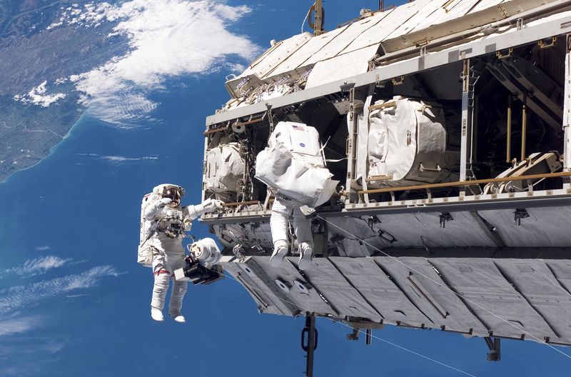 FILE - In this photo provided by NASA, astronaut Robert L. Curbeam Jr., left, and European Space Agency astronaut Christer Fuglesang, participate in a spacewalk during construction of the International Space Station on Dec. 12, 2006. In the background are New Zealand and the Pacific Ocean. (NASA via AP, File)