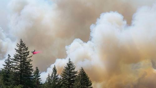 A plane drops fire retardant on the Park Fire near Forest Ranch, Calif., Sunday, July 28, 2024. (AP Photo/Nic Coury)