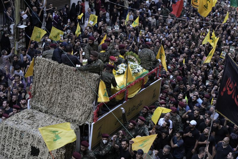 Hezbollah supporters march behind the hearse carrying the coffins of Hezbollah commander Ibrahim Akil and militant Mahmoud Hamad during their funeral procession in Beirut's southern suburb, Sunday, Sept. 22, 2024. (AP Photo/Bilal Hussein)