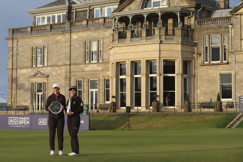 Lydia Ko, of New Zealand, right, the new Champion golfer with Lottie Woad the leading amateur pose for the media with their trophies after the end of the Women's British Open golf championship, in St. Andrews, Scotland, Sunday, Aug. 25, 2024. (AP Photo/Scott Heppell)