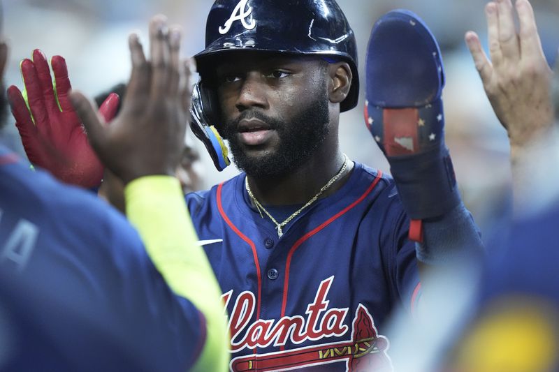 Atlanta Braves' Michael Harris II is congratulated by teammates after he scored on a single by Matt Olson during the fifth inning of a baseball game against the Miami Marlins, Sunday, Sept. 22, 2024, in Miami. (AP Photo/Wilfredo Lee)