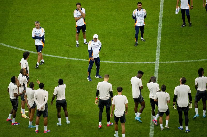 Real Madrid's head coach Carlo Ancelotti, centre, talks to players during a training session ahead of the UEFA Super Cup Final soccer match between Real Madrid and Atalanta at the Narodowy stadium in Warsaw, Poland, Tuesday, Aug. 13, 2024. (AP Photo/Darko Vojinovic)