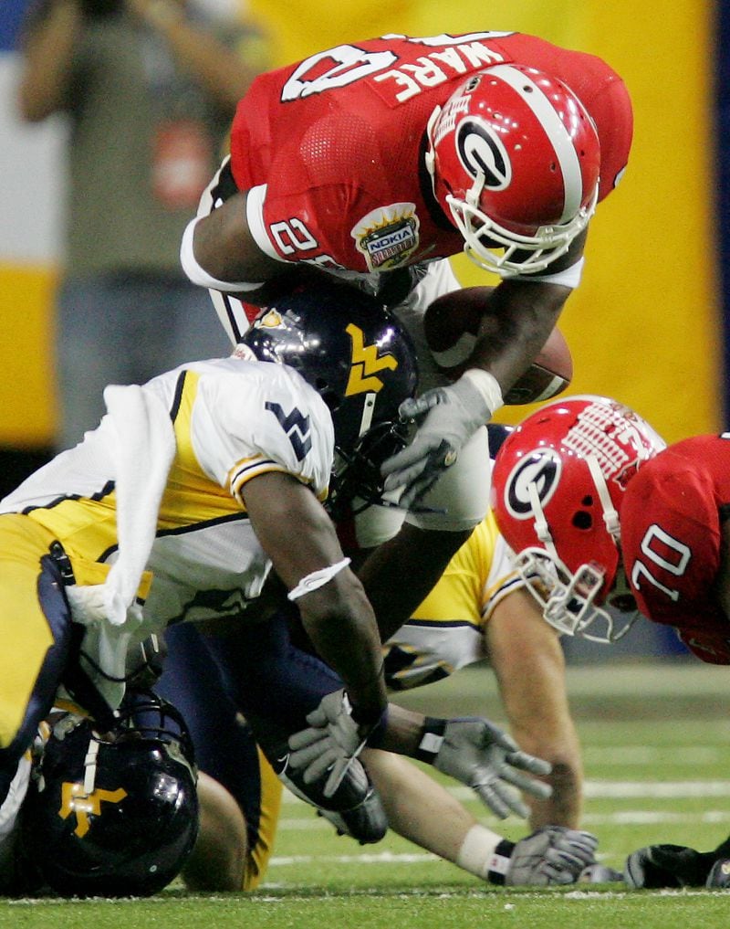 Georgia's Danny Ware (28) fumbles as he is hit by West Virginia's Jahmile Addae (left) in the first quarter of the Sugar Bowl on Monday, Jan. 2, 2006, at the Georgia Dome in Atlanta. West Virginia recovered the fumble. (John Bazemore/AP)