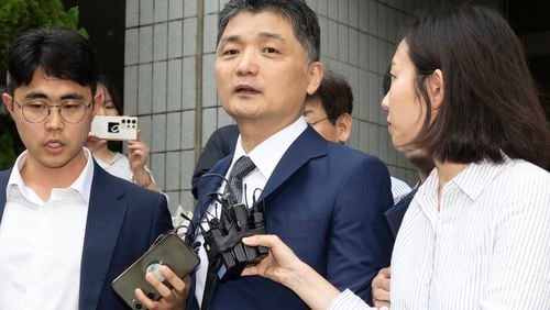 Kim Beom-su, center, the founder of the country's tech giant Kakao Corp., leaves a courtroom after a warrant hearing at the Seoul Southern District Court in Seoul, South Korea, Monday, July 22, 2024. (Yoon Dong-jin/Yonhap via AP)