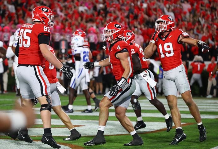 Georgia tight end Oscar Delp, center, celebrates his touchdown with tight end Brock Bowers, right, and teammates.  Curtis Compton for the Atlanta Journal Constitution