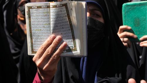 FILE -A demonstrator holds up a copy of the Quran, Islam's holy book, during a protest of the burning of a Quran in Sweden, in front of the Swedish Embassy in Tehran, Iran, June 30, 2023. (AP Photo/Vahid Salemi, File)