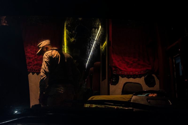 A National Guard officer ispects the interior of a passenger bus at an immigration checkpoint in Nuevo Teapa, southern Mexico, late Saturday, June 8, 2024. Mexico is under pressure from the U.S. to block millions of migrants headed north. (AP Photo/Felix Marquez)