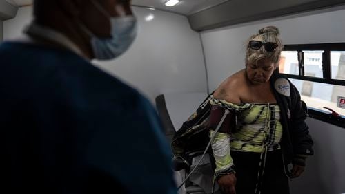 Norma Terrazas, right, gets her blood pressure checked by medical assistant Henry Gil Maturell in Wesley Health Centers' mobile clinic in the Skid Row area of Los Angeles, Tuesday, Aug. 27, 2024. (AP Photo/Jae C. Hong)