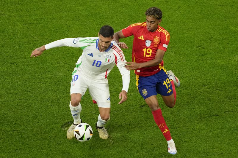 Italy's Lorenzo Pellegrini, left, challenges for the ball with Spain's Lamine Yamal during a Group B match between Spain and Italy at the Euro 2024 soccer tournament in Gelsenkirchen, Germany, Thursday, June 20, 2024. (AP Photo/Andreea Alexandru)
