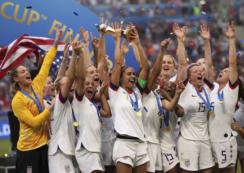 FILE - United States' Alex Morgan holds the trophy celebrating at the end of the Women's World Cup final soccer match between U.S. and The Netherlands at the Stade de Lyon in Decines, outside Lyon, France, Sunday, July 7, 2019. (AP Photo/Francisco Seco)