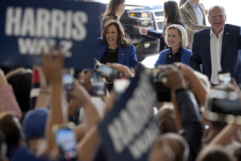 Democratic presidential nominee Vice President Kamala Harris, left, Democratic vice presidential nominee Minnesota Gov. Tim Walz, right, and his wife Gwen Walz arrive at Pittsburgh International Airport, Sunday, Aug. 18, 2024, in Pittsburgh, (AP Photo/Julia Nikhinson)