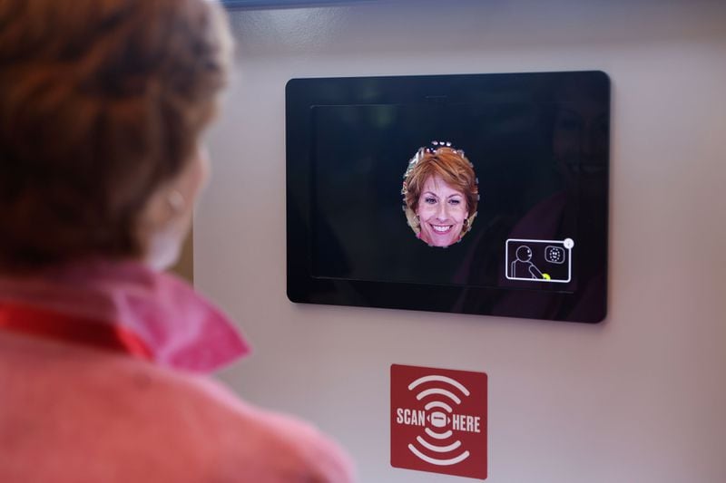 Jacquie Wansley scans her face at the kiosk for the new GAME ON! AI Experience at The College Football Hall of Fame in Atlanta on Friday, Aug. 23, 2024. GAME ON! uses generative AI to collect information that gives guests a customized fan experience throughout the exhibits. (Natrice Miller/ AJC)