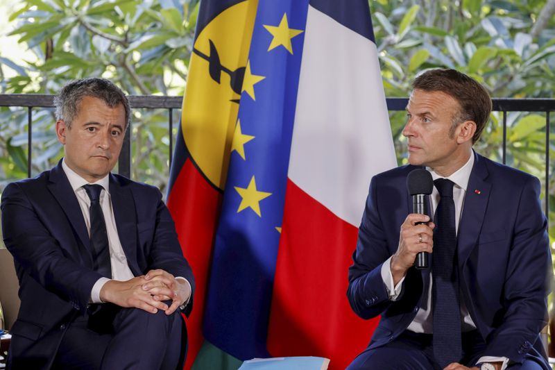 French President Emmanuel Macron speaks as sits next to France's Minister for Interior and Overseas Gerald Darmanin, left, during a meeting with New Caledonia's elected officials at the French High Commissioner Louis Le Franc's residence in Noumea,New Caledonia, Thursday, May 23, 2024. Macron has landed in riot-hit New Caledonia, having crossed the globe by plane from Paris in a high-profile show of support for the French Pacific archipelago wracked by deadly unrest and where indigenous people have long sought independence from France. (Ludovic Marin/Pool Photo via AP)