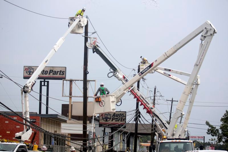 Utility crews work to restore electricity in Houston, Thursday, July 11, 2024. Officials say about 500,000 customers still won't have electricity into next week as wide outages from Hurricane Beryl persist. (AP Photo/Lekan Oyekanmi)