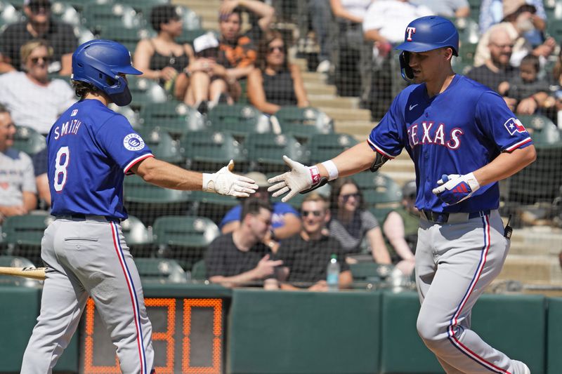 Texas Rangers' Corey Seager, right, celebrates with Josh Smith after hitting a solo home run during the fourth inning of a baseball game against the Chicago White Sox in Chicago, Thursday, Aug. 29, 2024. (AP Photo/Nam Y. Huh)