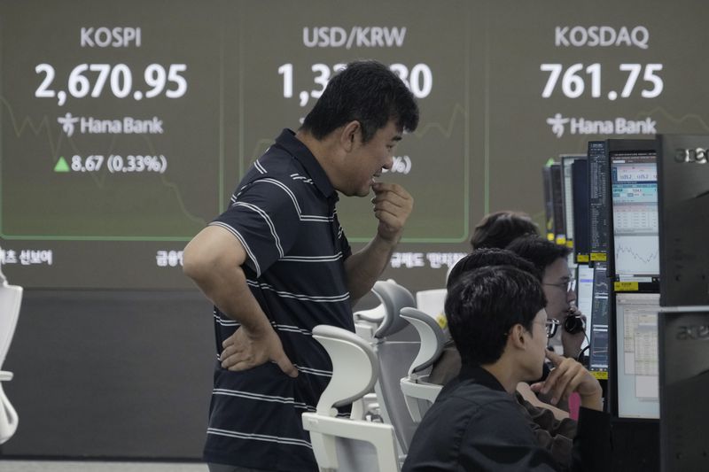 Currency traders watch monitors near a screen showing the Korea Composite Stock Price Index (KOSPI), top left, at the foreign exchange dealing room of the KEB Hana Bank headquarters in Seoul, South Korea, Friday, Aug. 30, 2024. (AP Photo/Ahn Young-joon)