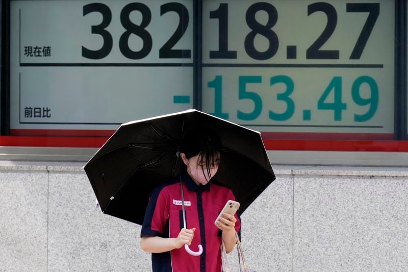 A person walks in front of an electronic stock board showing Japan's Nikkei index at a securities firm Thursday, Aug. 29, 2024, in Tokyo. (AP Photo/Eugene Hoshiko)