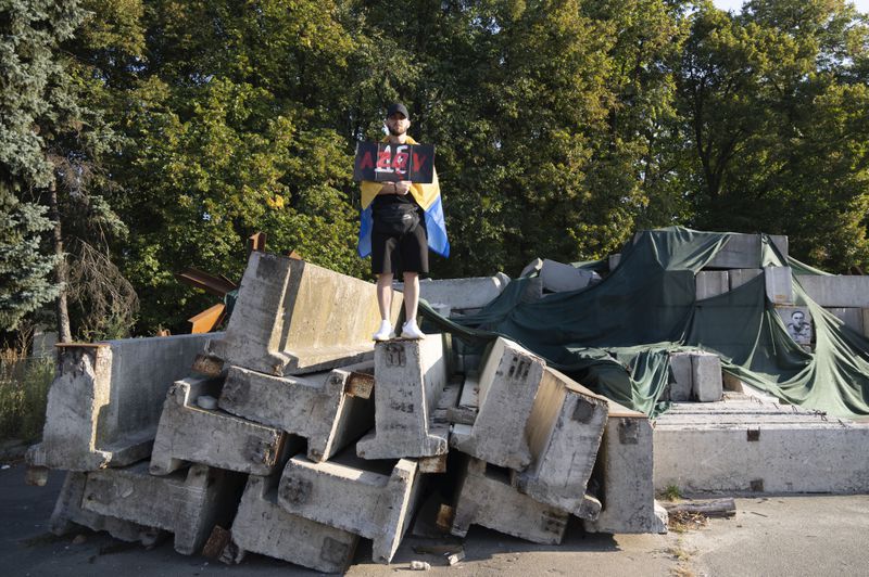 A man holds a sign as he participates in the weekly protest in Kyiv, Ukraine, Sunday Sept. 22, 2024 concerning the plight of Ukrainian Azovstal defenders still being held prisoner by the Russians. (AP Photo/Tony Hicks)