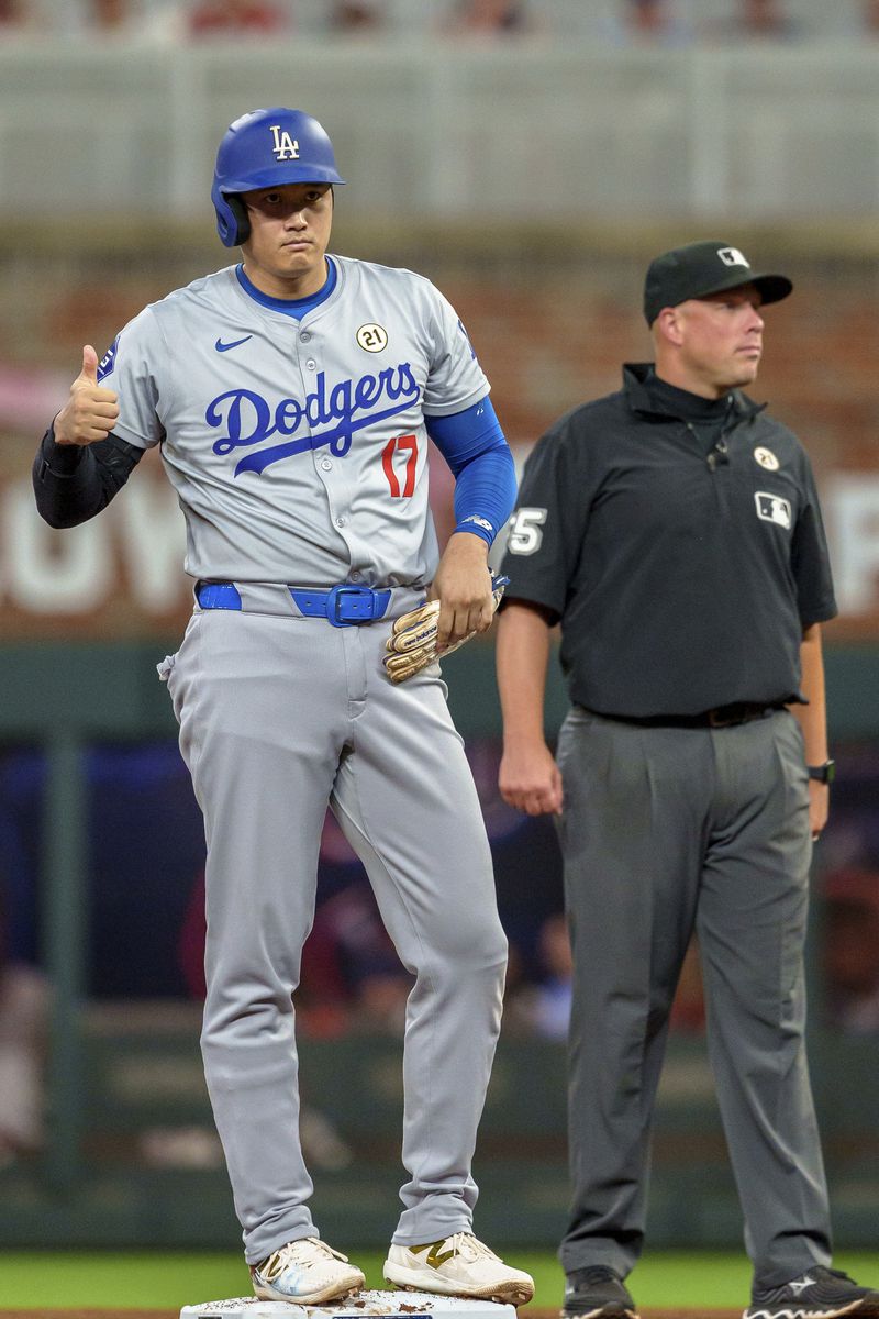 Los Angeles Dodgers' Shohei Ohtani gives a thumbs up to the dugout after hitting a double in the fifth inning of a baseball game against he Atlanta Braves, Sunday, Sept. 15, 2024, in Atlanta. (AP Photo/Jason Allen)