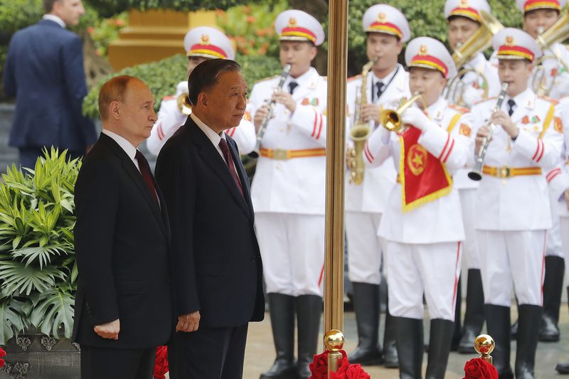 Vietnamese President To Lam, right, and his Russian counterpart Vladimir Putin review the guard of honor at the Presidential Palace in Hanoi, Vietnam, Thursday, June 20, 2024. (AP Photo/Minh Hoang, Pool)