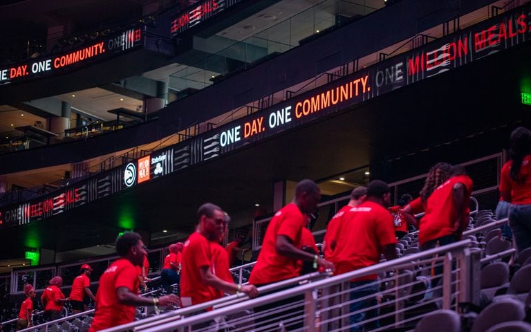 Volunteers leave the stadium after packing red lentil jambalaya kits for local food banks.   (Jenni Girtman for The Atlanta Journal-Constitution)