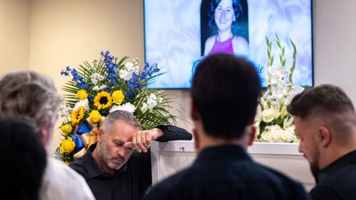 Dorin Irimie, husband of Ana Cristina Irimie, a math teacher killed at Apalachee High School during a school shooting, mourns by her casket at her funeral service at Hamilton Mill Memorial Chapel and Gardens in Buford on Saturday, September 14, 2024. (Arvin Temkar / AJC)