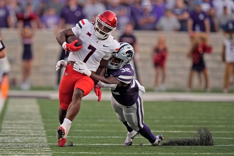 Arizona running back Quali Conley (7) is tackled by Kansas State linebacker Desmond Purnell (32) during the first half of an NCAA college football game Friday, Sept. 13, 2024, in Manhattan, Kan. (AP Photo/Charlie Riedel)