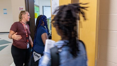 A teacher welcomes students on the first day of school at Sandy Springs Charter Middle School in Sandy Springs on Monday, Aug. 8, 2022. (Arvin Temkar / arvin.temkar@ajc.com)