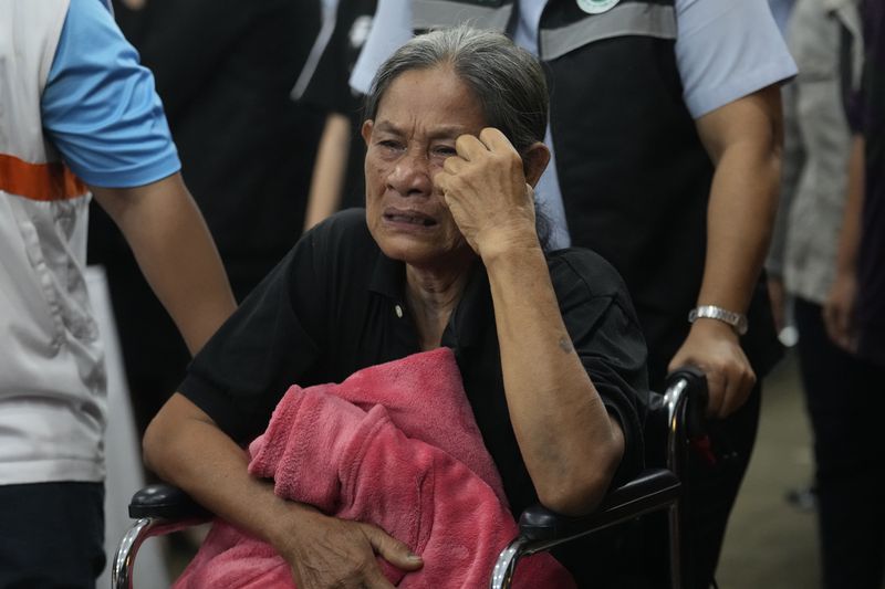 A grieving family member cries during the coffin procession for victims of a bus fire at Wat Khao Phraya Sangkharam School Lan Sak , Uthai Thani province, Thailand, Thursday, Oct. 3, 2024. AP Photo/Sakchai Lalit)