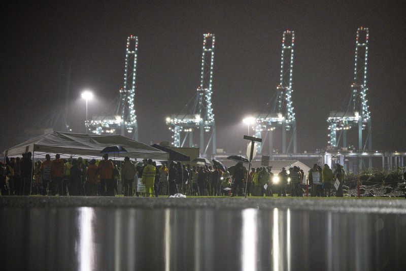 Hundreds of longshoremen strike together outside of the Virginia International Gateway in Portsmouth, Va., Tuesday, Oct. 1, 2024. (Billy Schuerman/The Virginian-Pilot via AP)