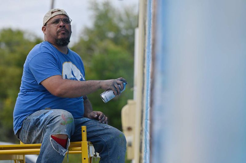 Kevin “Scene” Lewis works on a mural of Rev. Martin Luther King Jr. on Wednesday, Sept. 11, 2024, off of Martin Luther King Jr. Boulevard in Macon, Georgia. The mural will depict King as well as cherry blossoms and Zion Baptist Church, the last place King visited in Macon before his assassination in 1968. (Photo Courtesy of Katie Tucker/The Telegraph)