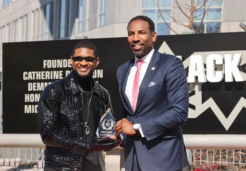 (Left to right) Recording artist Usher receives the Phoenix Award from Mayor Andre Dickens at The Black Music Walk of Fame in Atlanta on Wednesday, Feb. 14, 2024. (Natrice Miller/ Natrice.miller@ajc.com)