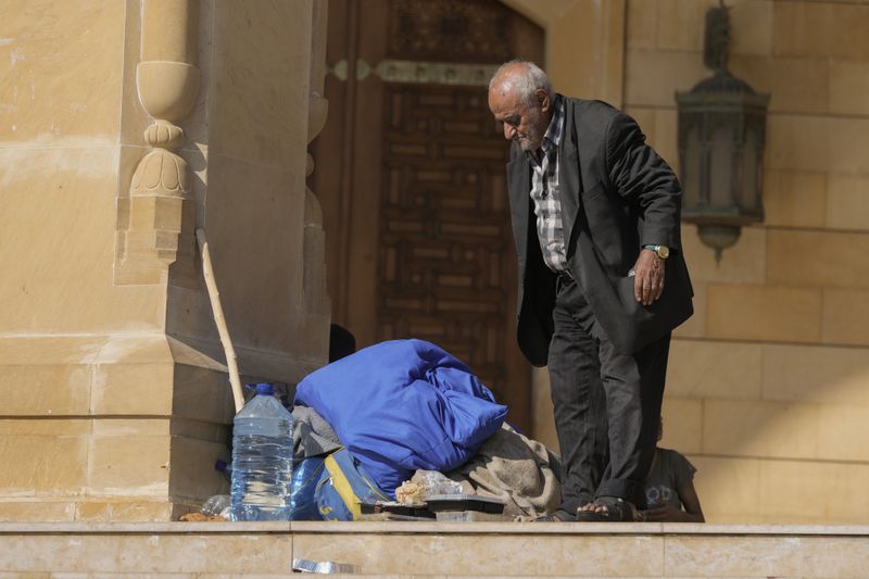 An elderly man stands near al-Amin Mosque in Beirut's Martyrs' square after fleeing the Israeli airstrikes in the southern suburbs of Dahiyeh, Sunday, Sept. 29, 2024. (AP Photo/Bilal Hussein)