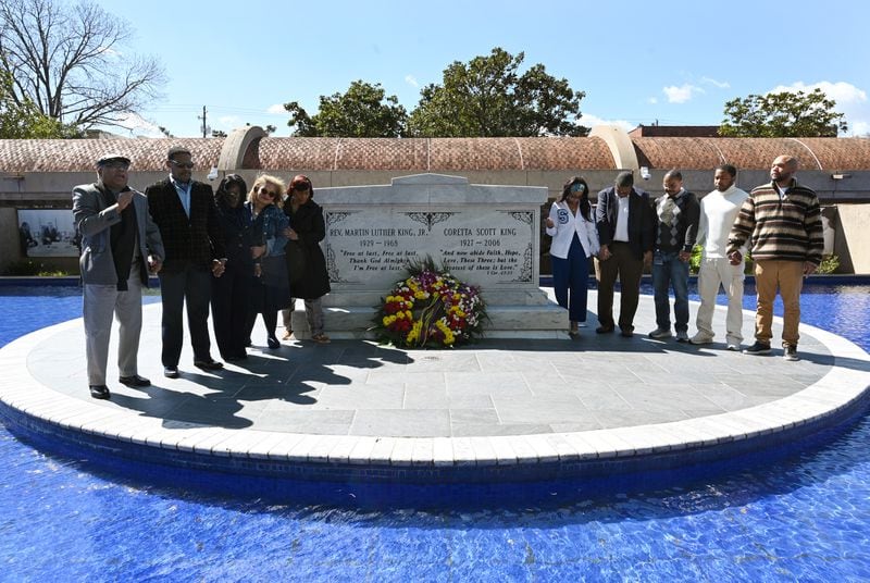 Derek Barber King (left), nephew of Martin Luther King Jr., leads the family and gatherers in prayer. 