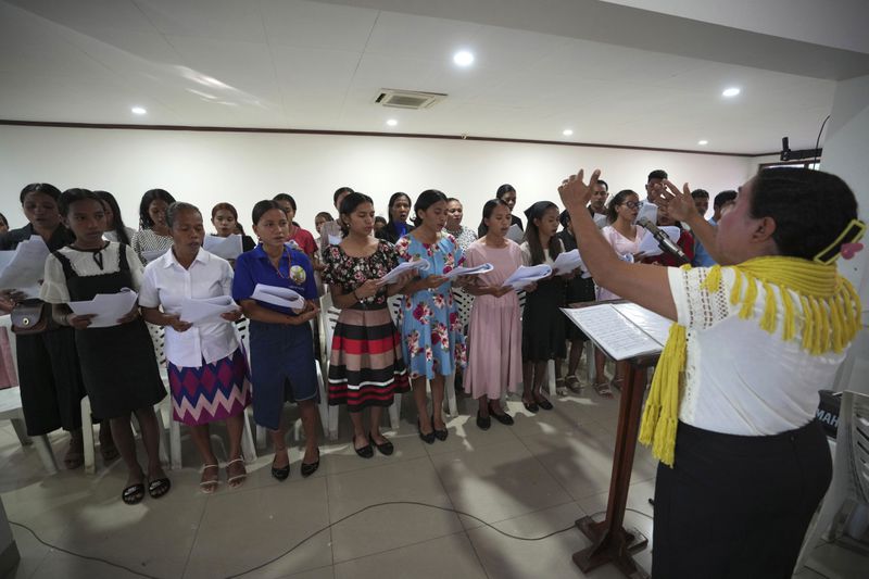 Timorese women sing during mass at a church In Dili, East Timor, Sunday, Aug. 11, 2024. (AP Photo/Achmad Ibrahim)