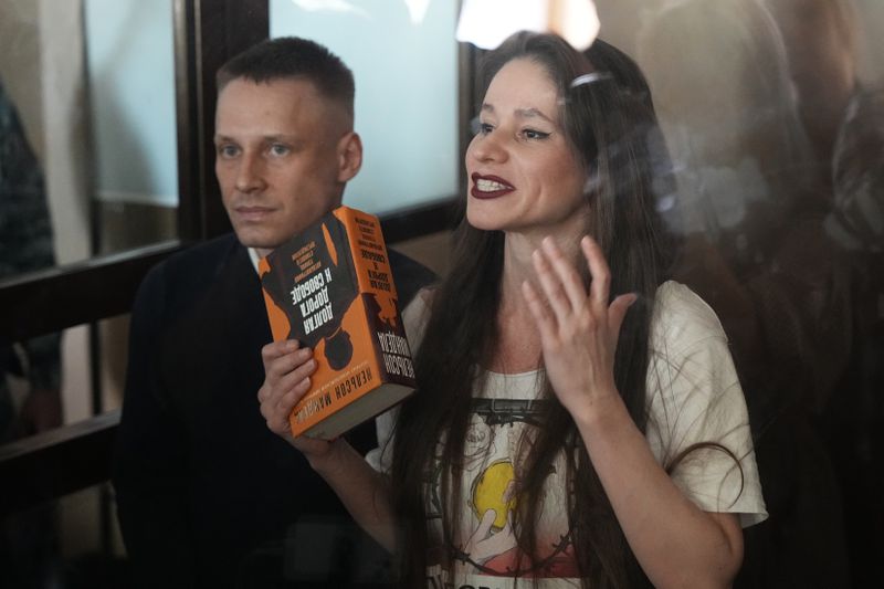 Russian journalists Konstantin Gabov, left, and Antonina Favorskaya, accused of working for a group founded by the late Russian opposition politician Alexei Navalny, stand in a defendant's cage of the Nagatinsky District Court in Moscow, Russia, on Wednesday, Oct. 2, 2024. (AP Photo)