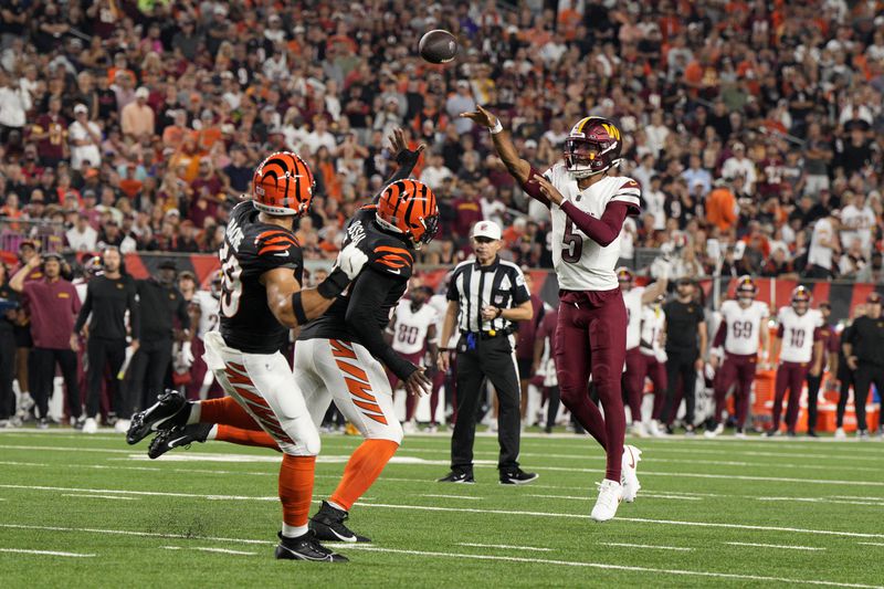 Washington Commanders quarterback Jayden Daniels (5) throws a touchdown pass during the second half of an NFL football game against the Cincinnati Bengals, Monday, Sept. 23, 2024, in Cincinnati. (AP Photo/Jeff Dean)